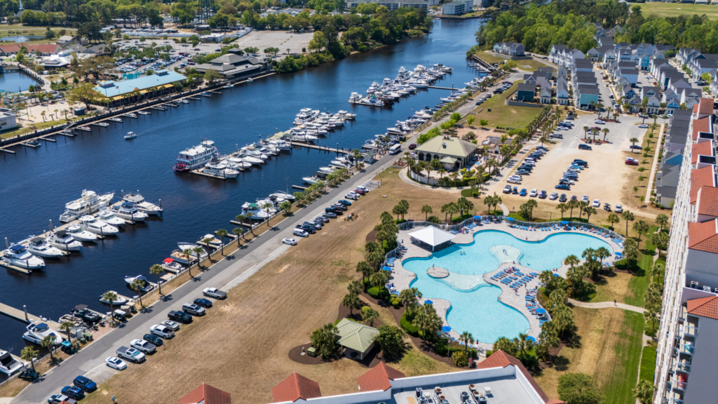 Aerial view of Barefoot Landing Marina in North Myrtle Beach with resort pool, boat slips along the Intracoastal Waterway, and Barefoot Landing Resort across the water.