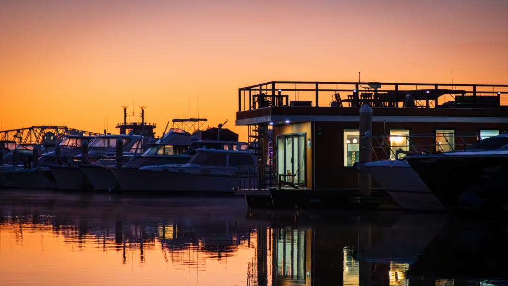 FLOHOM 15 Palmera luxury houseboat docked at Barefoot Landing Marina in North Myrtle Beach at sunrise with boats reflected on the Intracoastal Waterway.