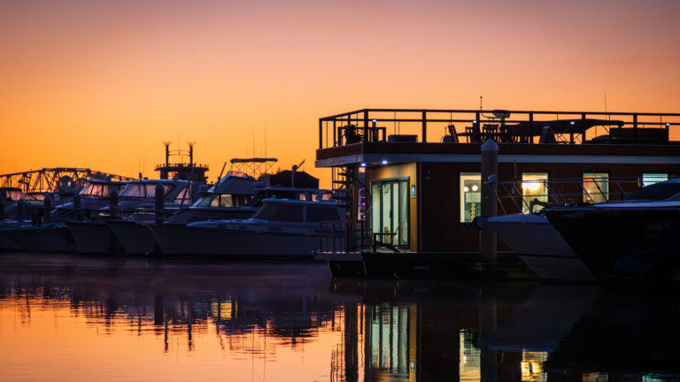 FLOHOM 15 Palmera luxury houseboat docked at Barefoot Landing Marina in North Myrtle Beach at sunrise with boats reflected on the Intracoastal Waterway.