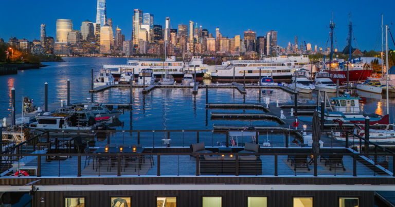 FLOHOM 16 Isaac's Way rooftop deck at Liberty Landing Marina with Lower Manhattan skyline and One World Trade across the Hudson